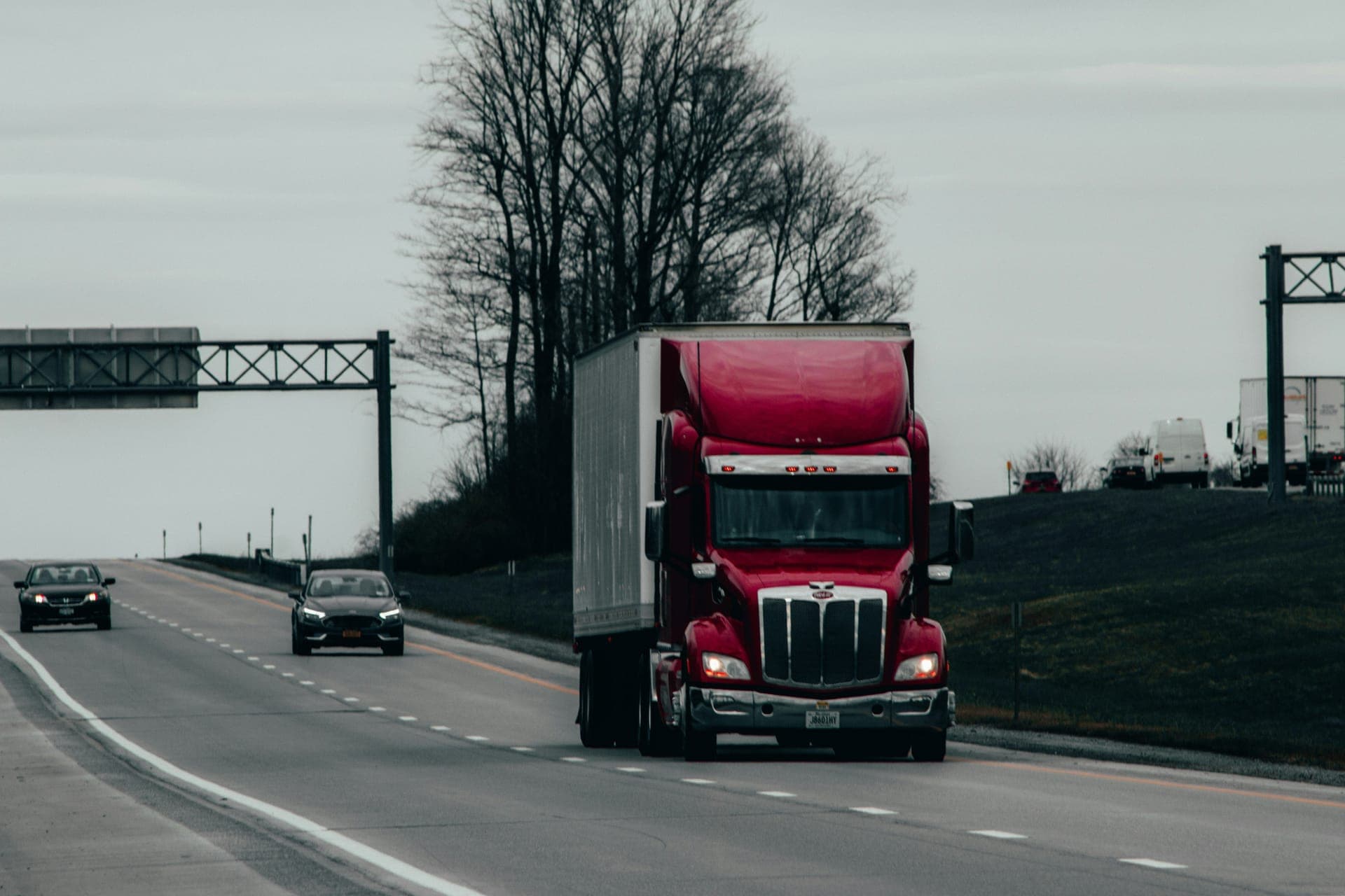 Red Peterbilt semi-truck with trailer on a US highway