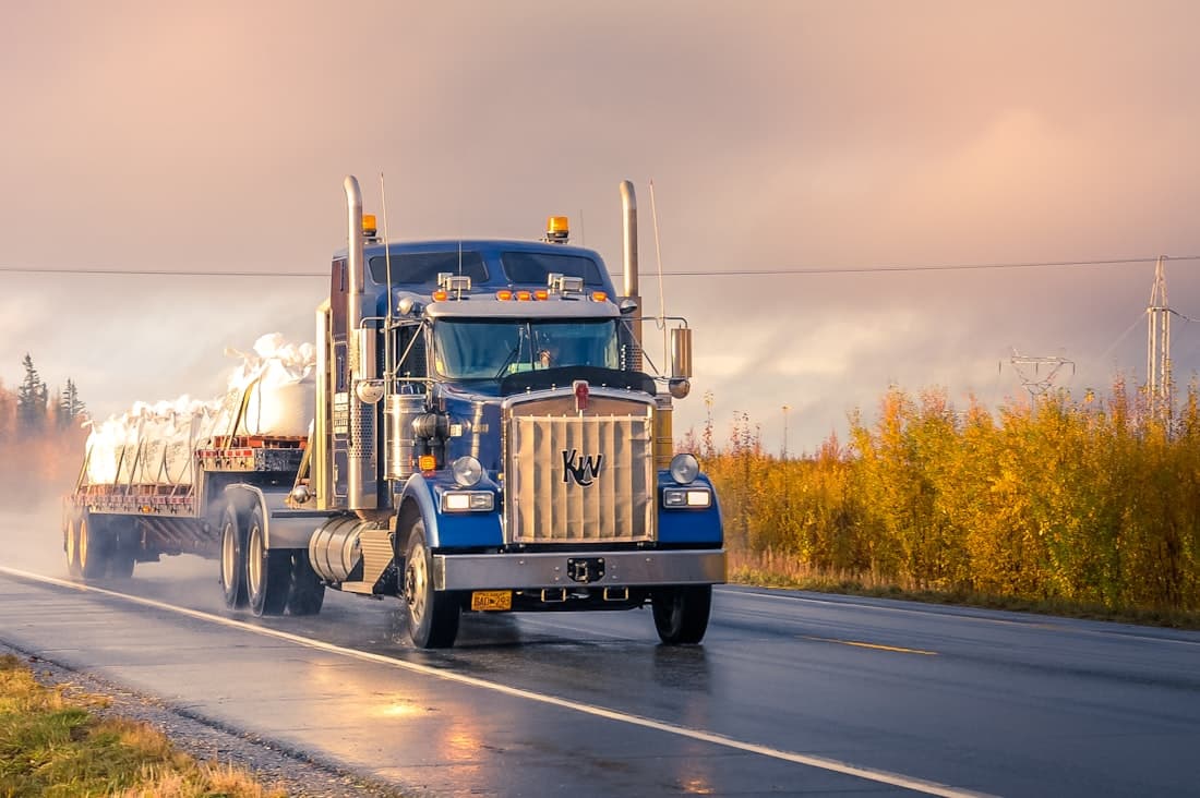 Heavy semi-truck and trailer traveling on the highway