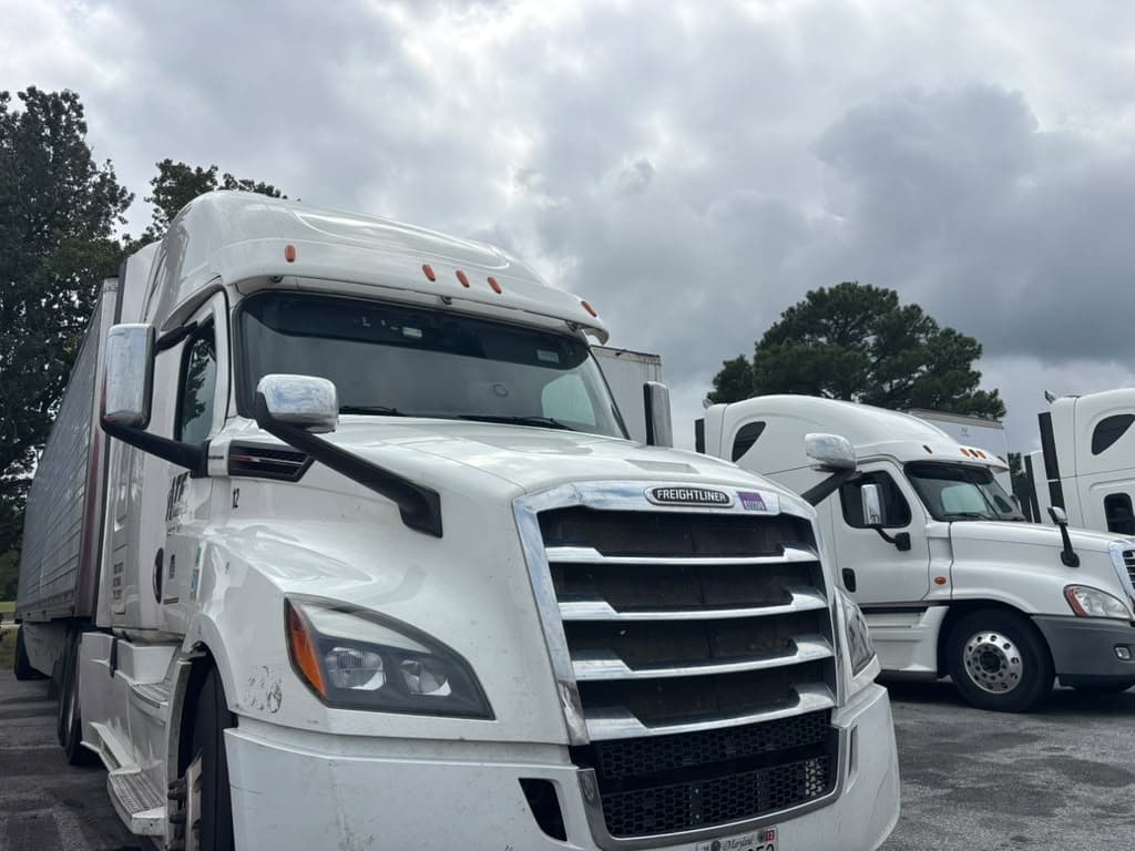 White Freightliner Cascadia Class 8 commercial highway tractor pulling a semitrailer