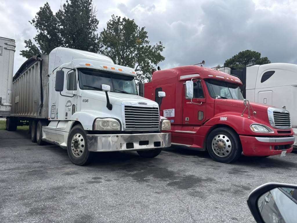 Heavy-duty commercial highway freight tractors in fleet parking yard equipped with electronic logging device technology